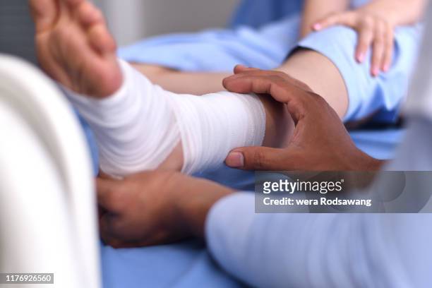 close up hand of doctor wrapping a bandage to the of sprained ankle patients - elastic bandage 個照片及圖片檔