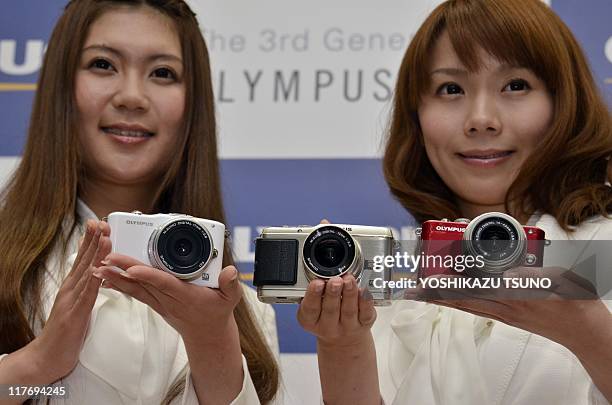 Models display the new interchangeable lens digital cameras of Japanese camera giant Olympus "Pen mini E-PM1", "Pen E-P3", and "Pen lite E-PL3",...