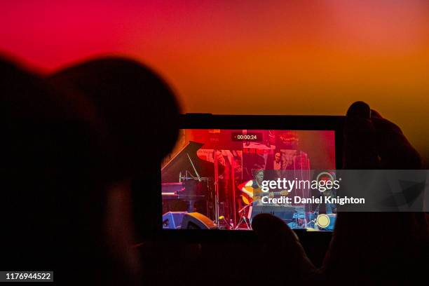 Fan takes cell phone video of guitarist Al Di Meola performing on stage at The Magnolia on September 24, 2019 in El Cajon, California.