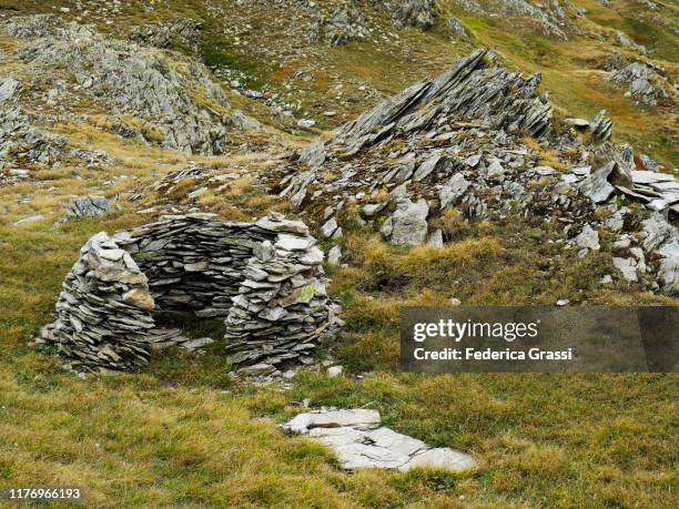 makeshift stone wall made by hikers as a windbreak at alpe naret - makeshift shelter stock pictures, royalty-free photos & images