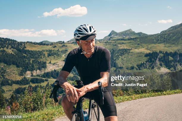 senior cyclist at top of col de joux verte - proud old man stock pictures, royalty-free photos & images