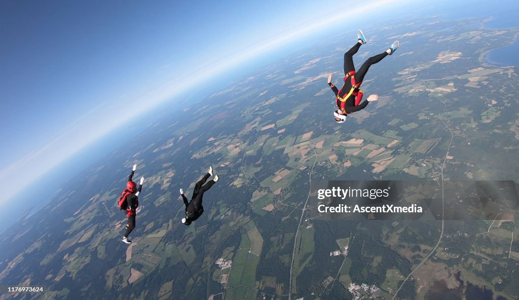 Skydivers fall through clear skies, aerial flight