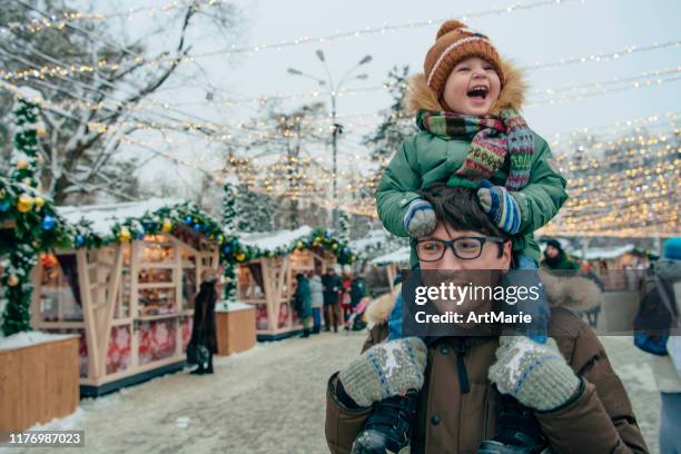 familia caminando por el mercado navideño - mercado navideño fotografías e imágenes de stock
