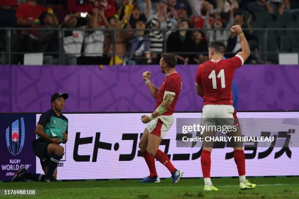 Wales' fly-half Dan Biggar and Wales' wing Joshua Adams react after winning the Japan 2019 Rugby World Cup quarter-final match between Wales and...