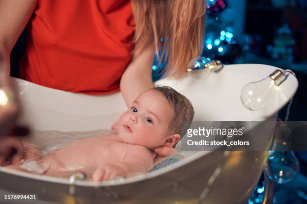 baby mädchen ein bad, weihnachtszeit - kid bath mother stock-fotos und bilder