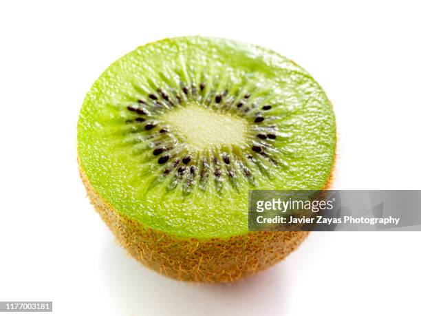 close-up of kiwi half over white background - kiwi fruit stock pictures, royalty-free photos & images