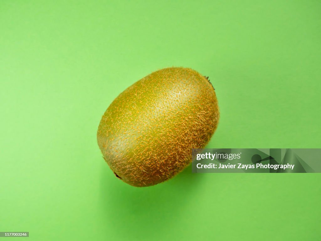 Close-Up Of Kiwi Against Green Background
