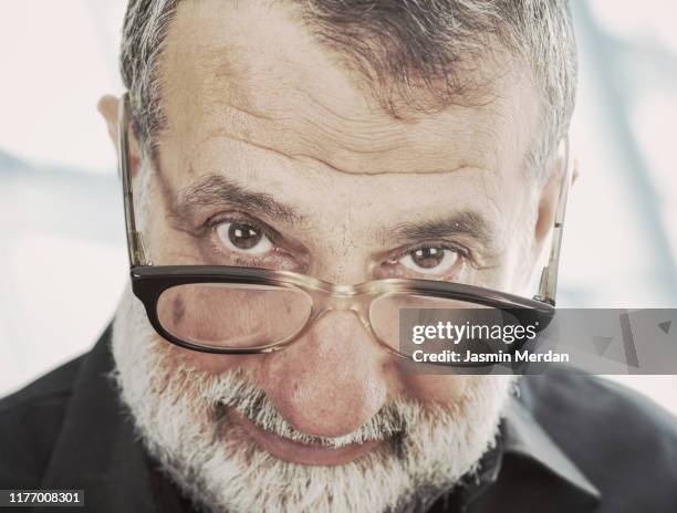 senior man with glasses suspicious look - suspicion office stock pictures, royalty-free photos & images