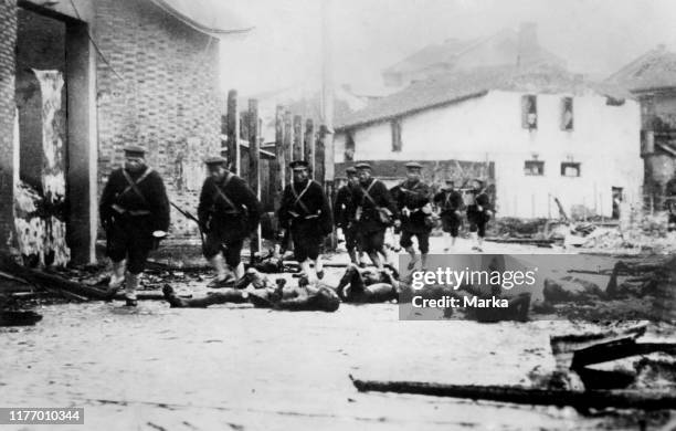 Asia. China. Troops of Japanese sailors passing through a village bombed Shanghai. 1937.