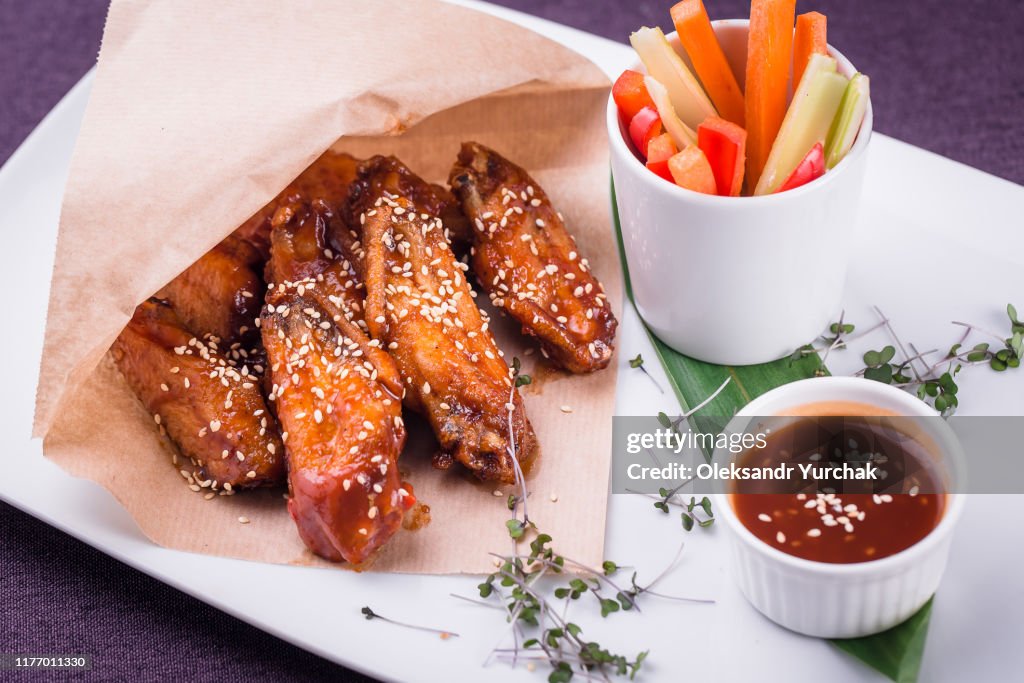 Buffalo chicken wings with sauce and vegetable sticks