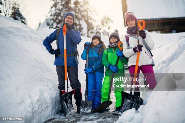 padre con niños limpiando nieve con palas - excavar fotografías e imágenes de stock