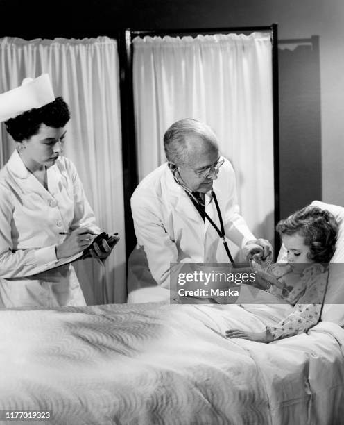 Doctor treat a little girl. 1950-1960.