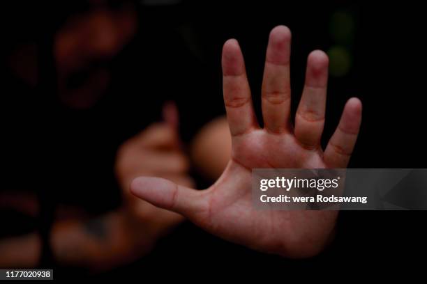 front view selective focus on palm of hand reach out one's hand from prison showing hand warning symbol - fuzzy handcuffs stock pictures, royalty-free photos & images