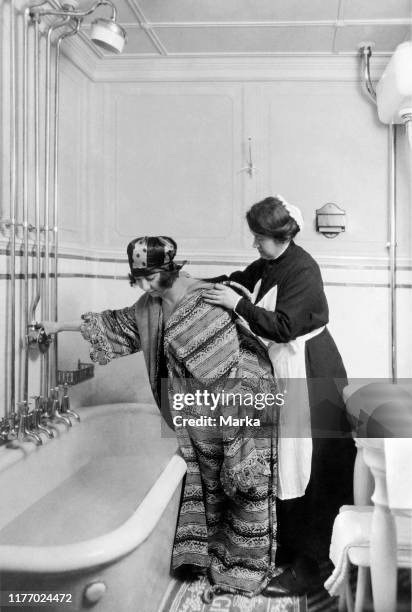 Tourist and maidservant in the bathroom of the neptunia transatlantic. 1930.