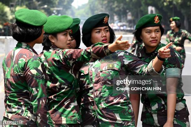 Indonesian security personnel gesture as they secure a street in Jakarta on October 20 as President Joko Widodo is inaugurated for his second...