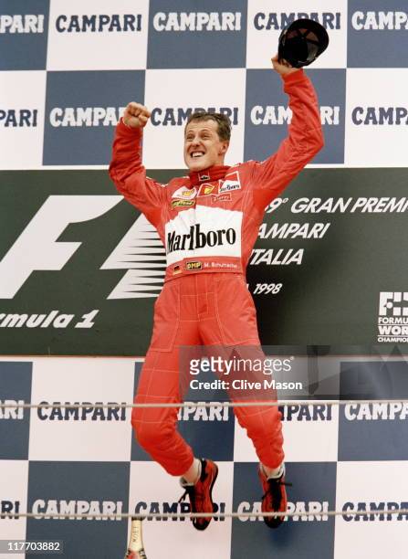 Michael Schumacher, driver of the Scuderia Ferrari Marlboro Ferrari F300 jumps into the air on the podium in celebration after winning the Italian...