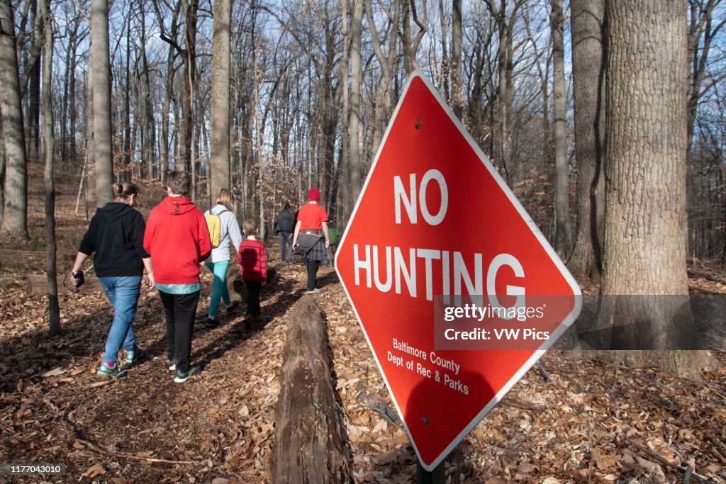 Warning signs notify the public that hunting is forbidden in the woods of Cromwell Valley park in Loch Raven, Maryland
