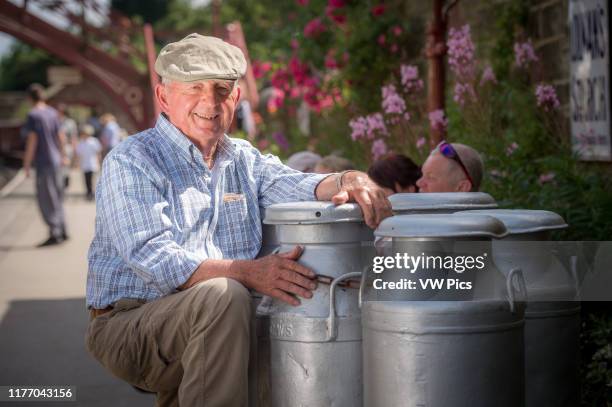 England, Yorkshire - a dairy farmer is photographed with milk cans at Goathland railway station.