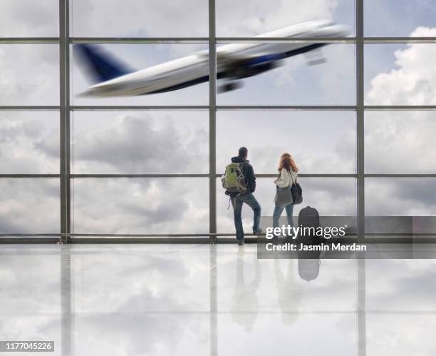 airplane taking off in airport terminal - dubai international airport - fotografias e filmes do acervo