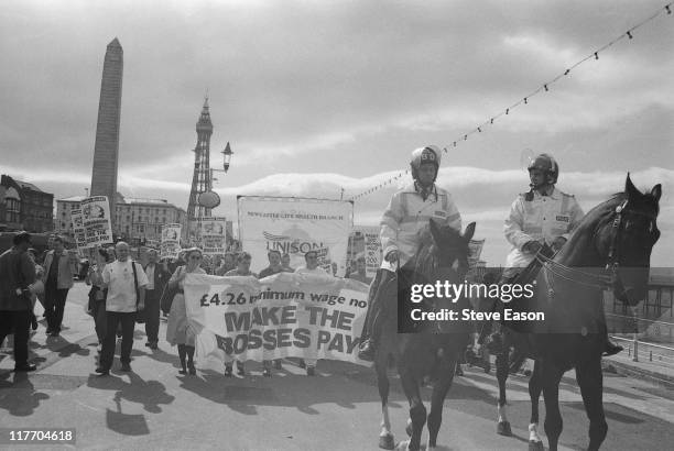 Mounted police lead a demonstration in support of a proposed 4.26 pound per hour minimum wage during the Trades Union Congress conference in...
