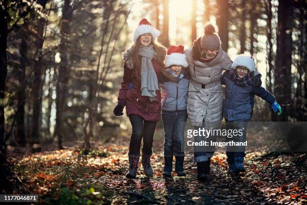 madre e bambini si divertono a camminare nella foresta. - daily life during christmas season in poland foto e immagini stock