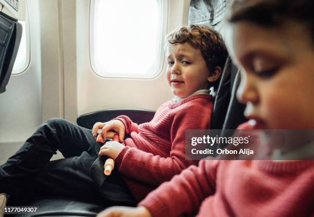 brothers on an airplane - crying sibling stock pictures, royalty-free photos & images