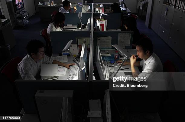 Lights are turned off at an SMBC Nikko Securities Inc. Office as employees work on desks equipped with light-emitting diode bulbs in an energy-saving...