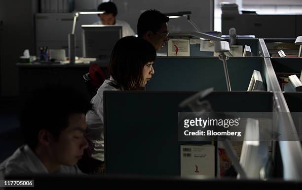Lights are turned off at an SMBC Nikko Securities Inc. Office as employees work on desks equipped with light-emitting diode bulbs in an energy-saving...