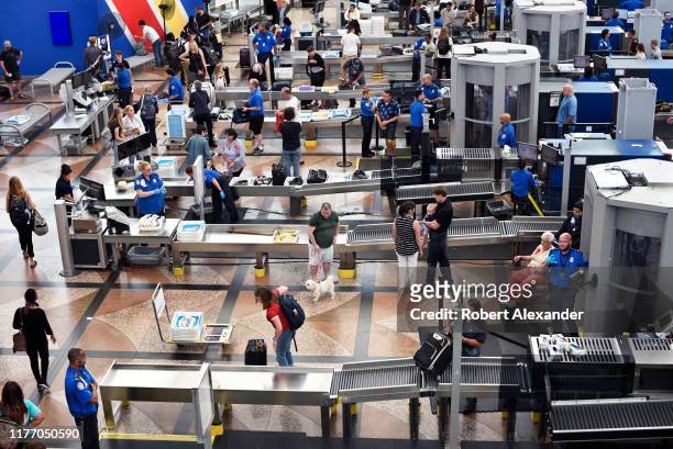 Airplane passengers proceed through the TSA security checkpoint at Denver International Airport in Denver, Colorado.