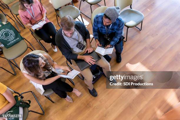high angle view of hipsters discussing expo brochure - diverse town hall meeting stock pictures, royalty-free photos & images