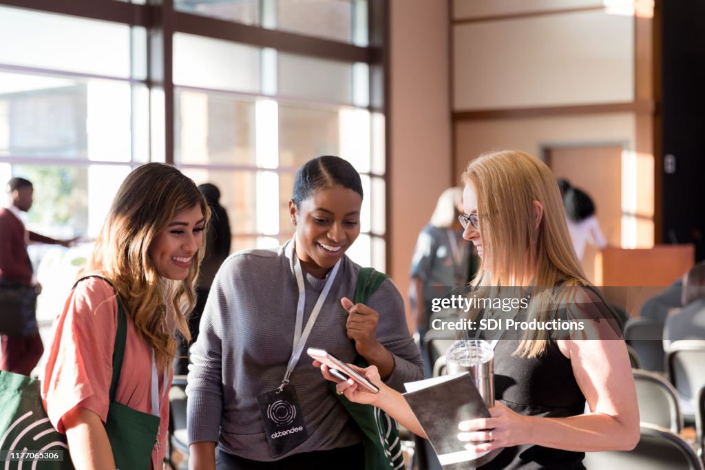 Diverse donne che partecipano a expo smile alle foto degli smartphone