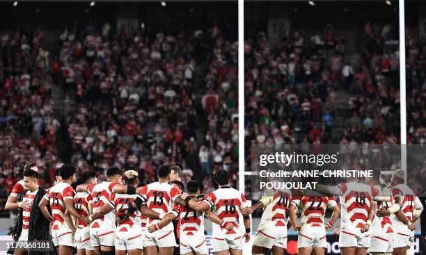 Japan's players huddle after losing the Japan 2019 Rugby World Cup quarter-final match between Japan and South Africa at the Tokyo Stadium in Tokyo...