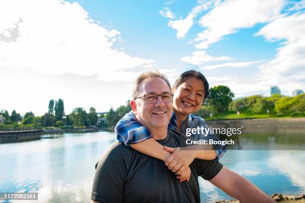 happy mature mixed race couple smiling together in vancouver canada - canadian culture stock pictures, royalty-free photos & images