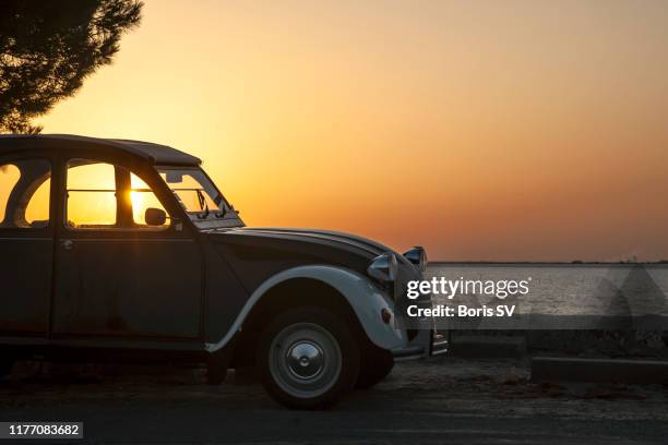 vintage car backlit by sunrise, arcachon bay, france - french culture stock-fotos und bilder