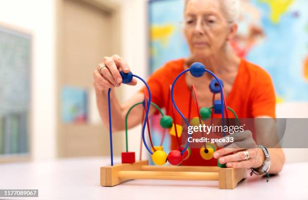 alte frau machen übung, warum sie alzheimer-krankheit geschützt ist - alzheimer's disease stock-fotos und bilder