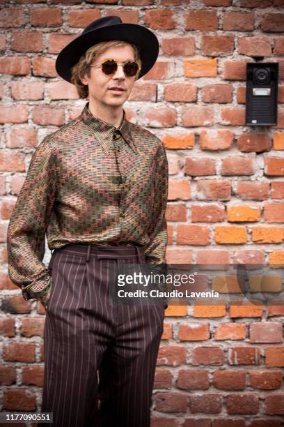 Beck Hansen, wearing printed shirt, brown striped pants and black hat, is seen outside the Gucci show during Milan Fashion Week Spring/Summer 2020 on...