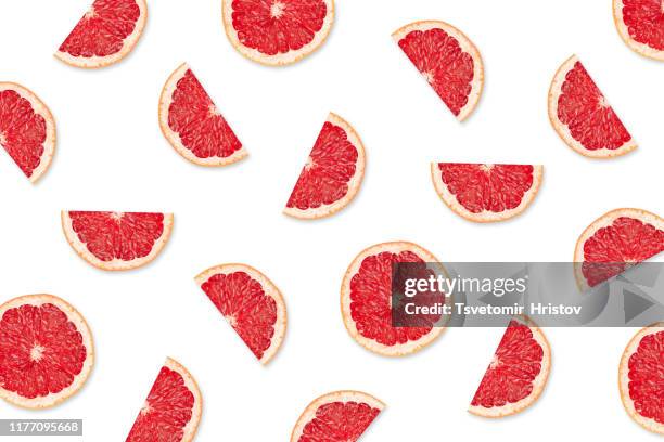 fruit pattern of  grapefruit slices on a white background - pompelmo foto e immagini stock