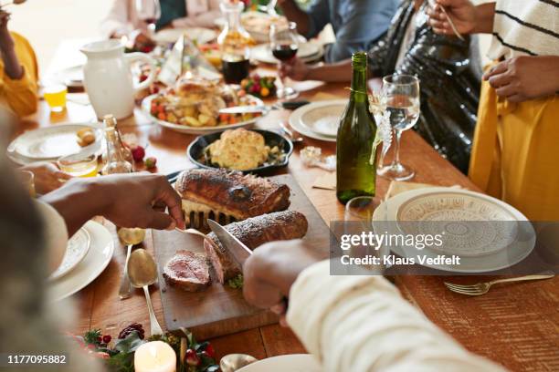 cropped hands of man cutting meat on dining table - cena con invitati foto e immagini stock