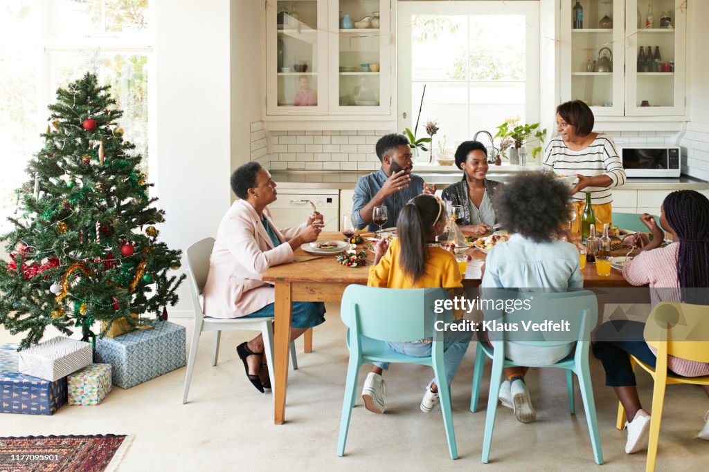 Family and friends talking while enjoying meal