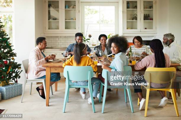 friends and family enjoying meal at home - black woman looking over shoulder stock pictures, royalty-free photos & images