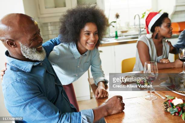 smiling teenage girl with man enjoying at home - adult laughing christmas stock pictures, royalty-free photos & images