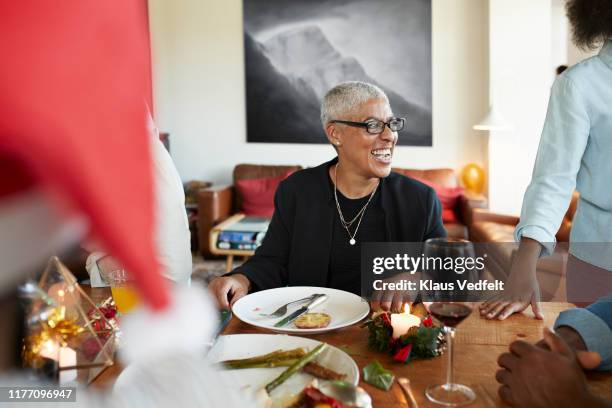 Woman laughing while sitting by table at home