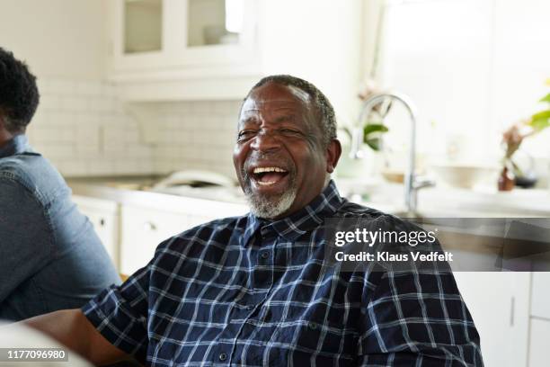 happy senior man laughing while sitting at home - heritage day south africa stock pictures, royalty-free photos & images