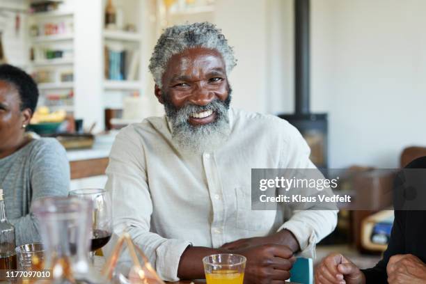 portrait of man enjoying with friends at home - 55 to 60 years old african american male stock pictures, royalty-free photos & images