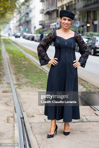 Agus Cattaneo, wearing a black midi dress, black hat and black heels, is seen outside the Dolce e Gabbana show during Milan Fashion Week...