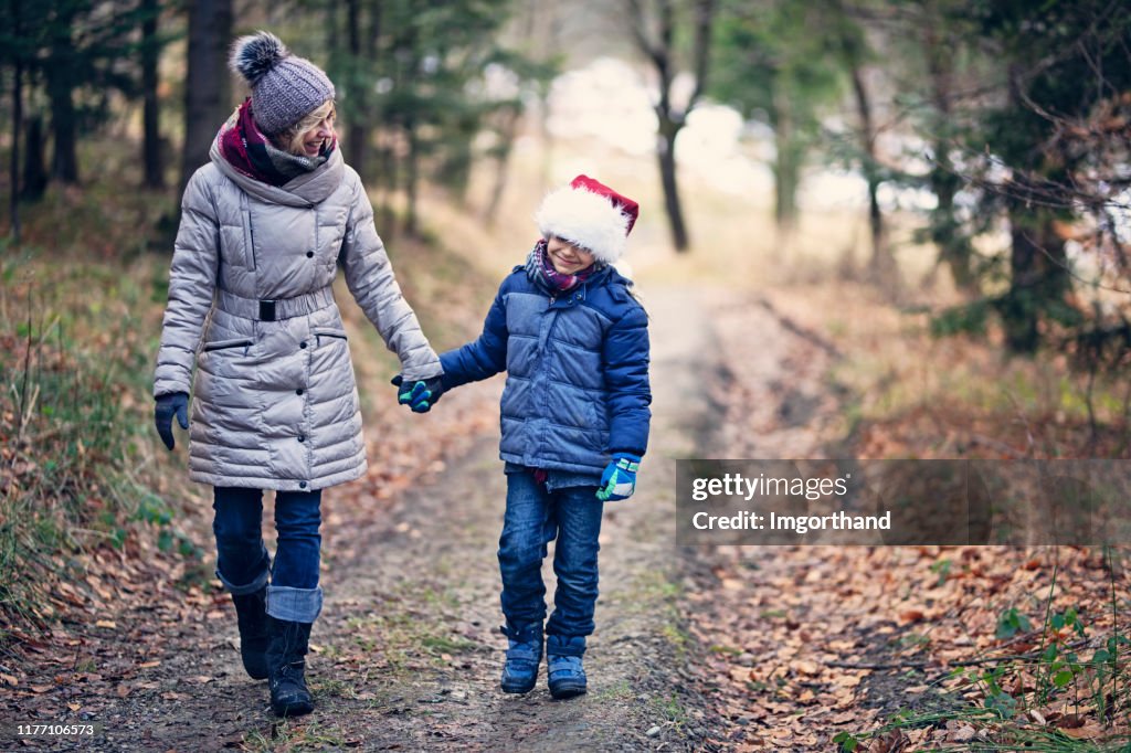 Mother and son enjoying walk in forest.