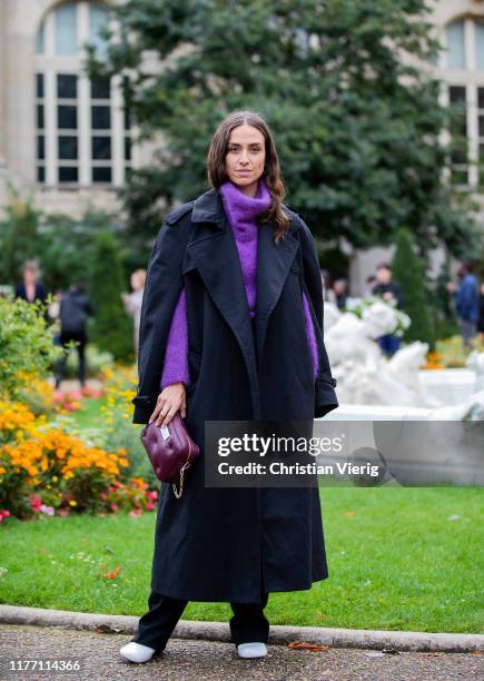 Erika Boldrin seen wearing purple turtleneck knit, black coat with slit, bordeaux mini bag outside Maison Margiela Show during Paris Fashion Week...