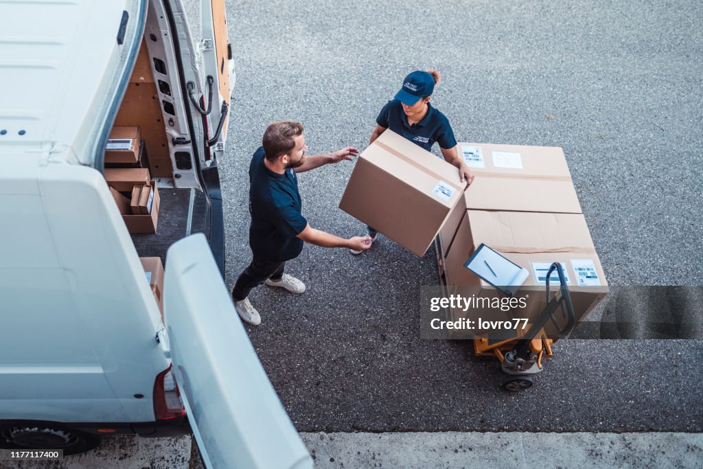 Mitarbeiter eilen, um Pakete in einen Lieferwagen zu laden
