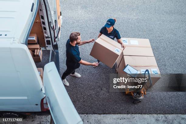 kollegor rusar för att ladda paket i en leverans van - delivery bildbanksfoton och bilder