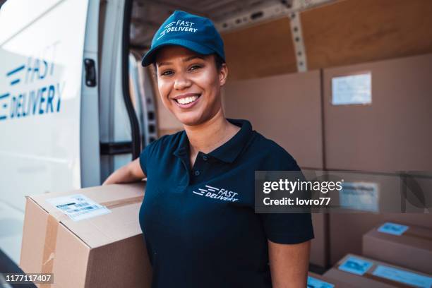 donna afroamericana in possesso di un pacco di consegna - postino foto e immagini stock